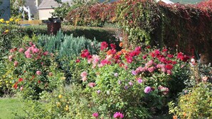 Ein Garten mit verschiedenen blühenden Pflanzen und einer Statue.