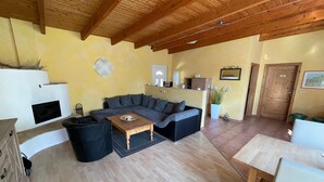 Ein gemütliches Wohnzimmer mit einer Eckcouch, einem Holztisch und einem Kamin.