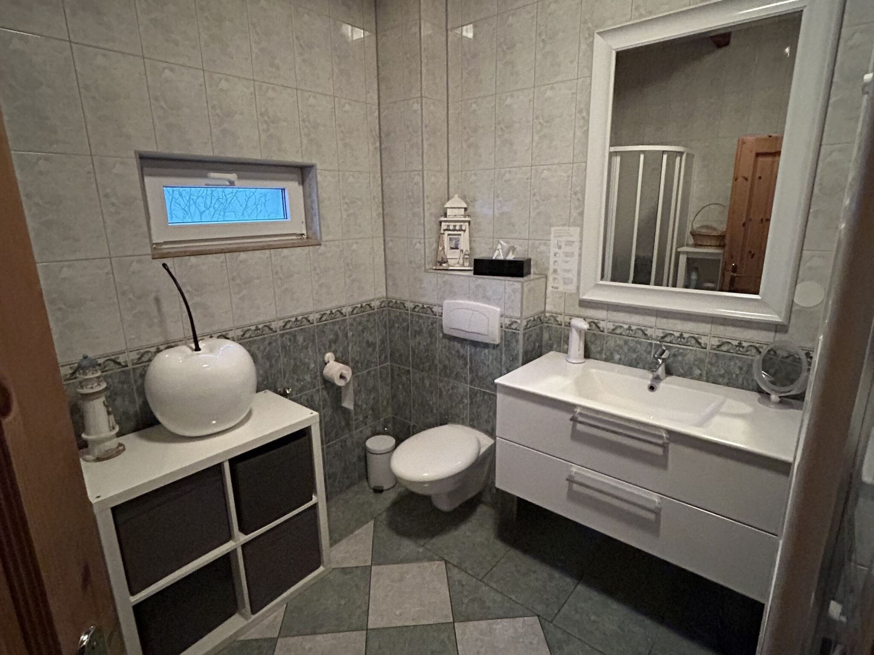 Ein Badezimmer mit Toilette, Waschbecken und Spiegel.