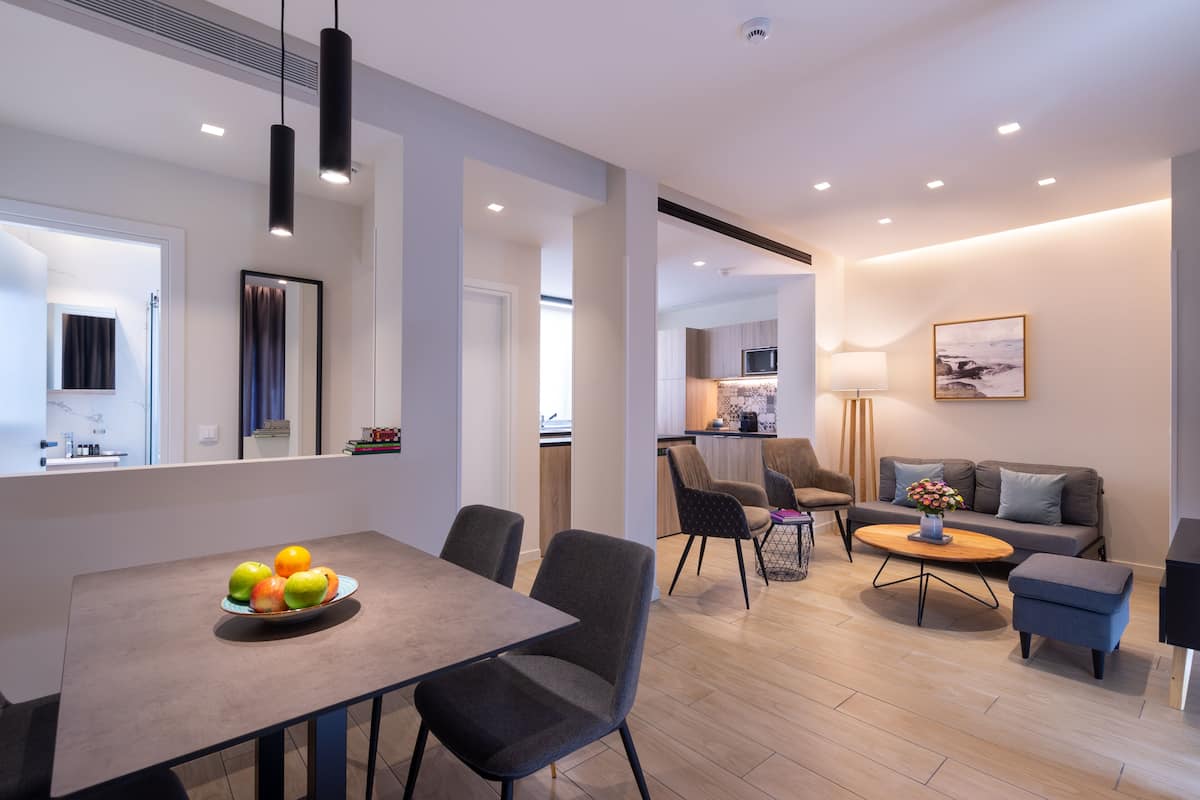 Een moderne woonkamer met een eettafel, stoelen, een bank en een salontafel.