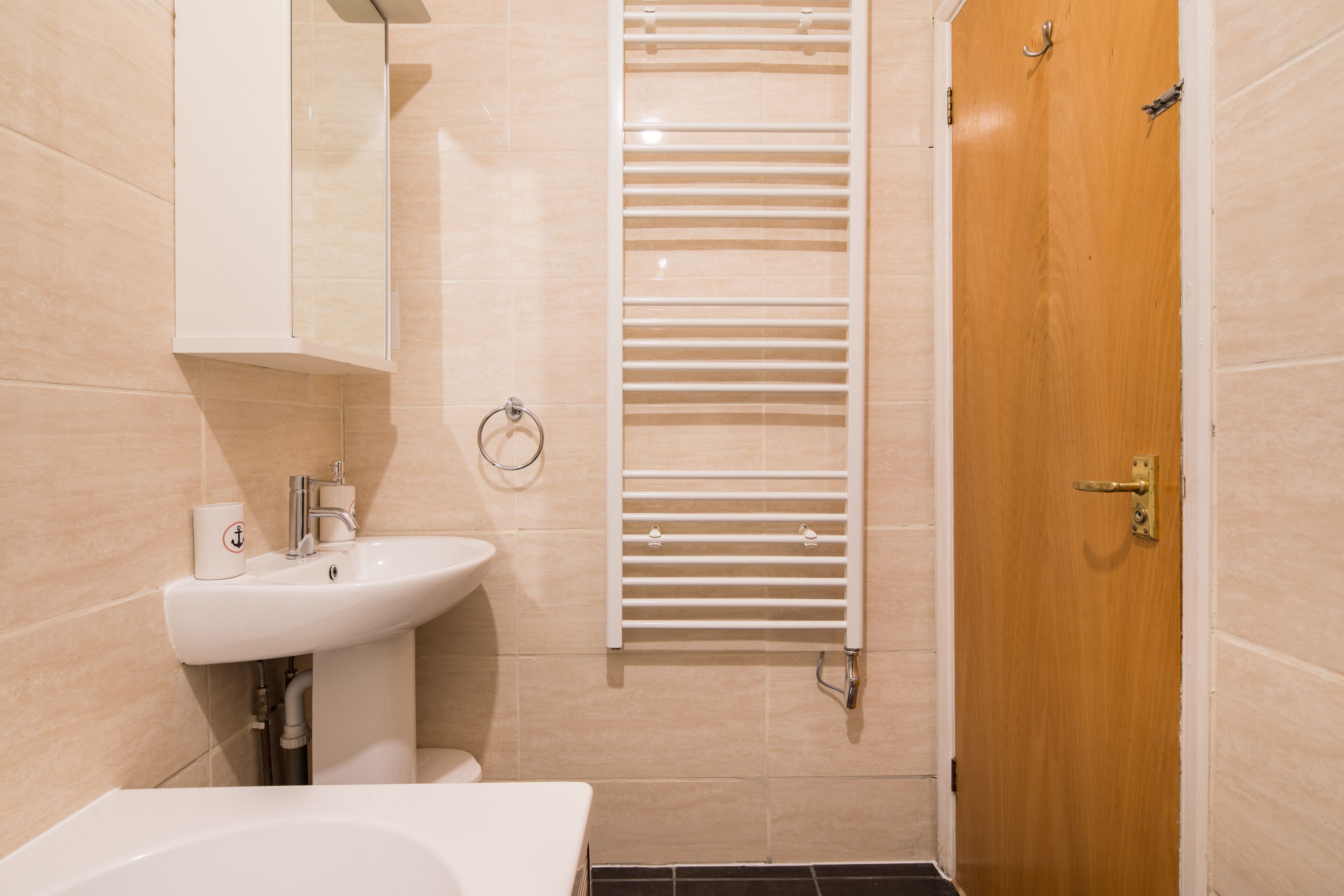 A bathroom with a sink, toilet, and a towel rack.