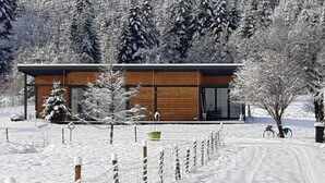 A modern building with a wooden facade, large windows, and a snow-covered landscape. - Family Escape With Garden (Saint-Quirin)