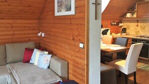 Interior acogedor de una cabaña con detalles de madera, un comedor y una cocina.