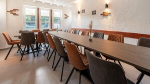 A conference room with a long table, multiple chairs, and a view of the outdoors through large windows. - Holiday Home Near Monschau With a Sauna (Schleiden)