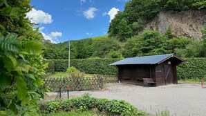 A rustic wooden cabin with a metal roof, surrounded by lush greenery and a clear sky. - Holiday Home Near Monschau With a Sauna (Schleiden)