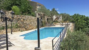 A swimming pool with stone walls, lounge chairs, and a stone staircase leading to a building. - Villa in Ampus With Panoramic Views & Pool (Ampus)