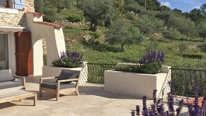 A stone building with a balcony, outdoor seating, and a view of a hillside with trees. - Villa in Ampus With Panoramic Views & Pool (Ampus)