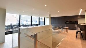 A modern kitchen with dark cabinets, a countertop, and a glass partition. - Luxurious Apartment in Nieuwpoort with Hot Tub (Nieuwpoort)