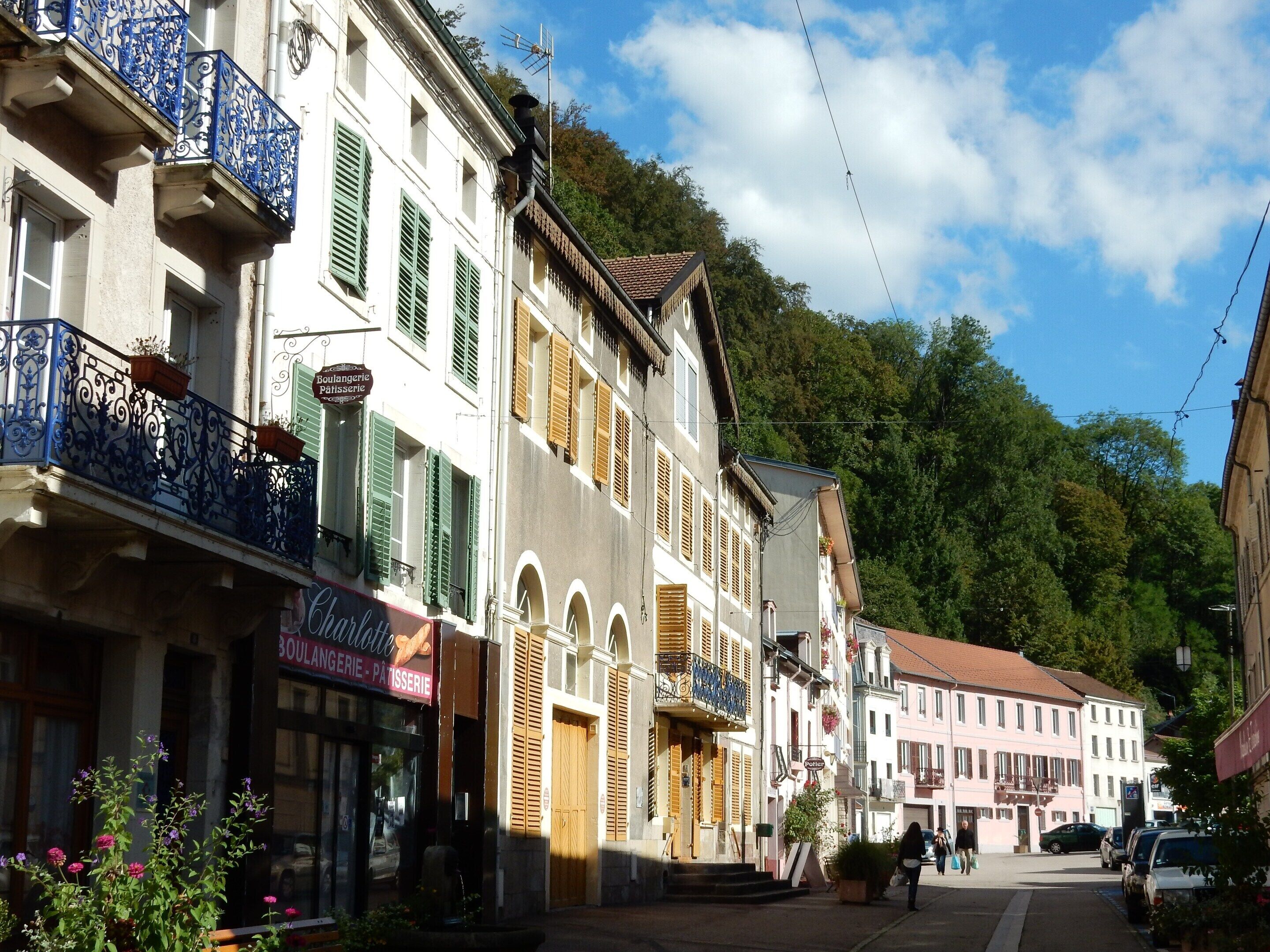 A street with buildings, including a bakery with a visible sign.