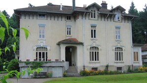 A large, two-story building with a symmetrical facade, multiple windows, and a central entrance with steps leading up to it. - Mansion in Vecoux With Pool and Garden (Vecoux)