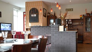 L’intérieur d’un restaurant présente des éléments décoratifs en briques, du mobilier en bois et un espace bar.