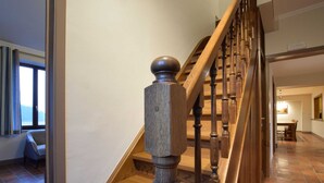 A wooden staircase with a handrail and a view of a dining area in the background. - Holiday Home in Rogery With Sauna (Gouvy)