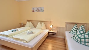 A hotel room with a large bed, a smaller sofa, a nightstand with a lamp, and a wall-mounted artwork. - Sunlit Apartment near Ski Area in Hüttschlag (Huettschlag)