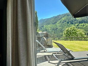 A balcony with a view of a forested mountain.
