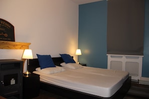 A hotel room with a bed, two bedside lamps, a heater, and a wall-mounted sign. - Villa With Spa & Pool (Channay)