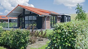 A modern house with a red-tiled roof, large windows, and a brick exterior. - Comfortable and Tasteful Holiday Home Near the Oosterschelde (Kattendijke)