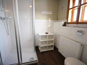 A bathroom with a shower, a toilet, and a sink.