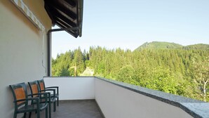 Un balcón con vistas a una montaña boscosa.