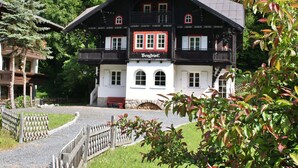 A traditional chalet with a balcony, a sign reading "Bergfriis," and a stone wall in front. - Spacious Villa in Zell am See near Ski Area (Zell am See)
