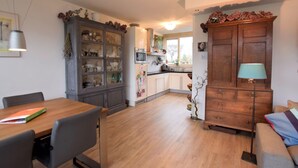 Una cocina moderna con comedor, armarios de madera y vistas al exterior.