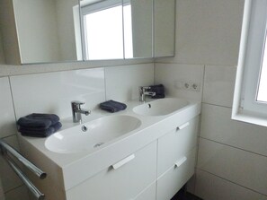 A modern bathroom with a double sink, a large mirror, and a towel rack. - Detached Chalet Close to the ski Area (Bruck an der Grossglocknerstrasse)
