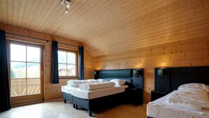 A wooden-paneled bedroom with two beds, a large window, and a view of a mountain. - Chalet in Mauterndorf Near Ski Slopes (Mauterndorf)