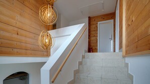 A staircase with wooden railings and a modern light fixture. - Chalet in Mauterndorf Near Ski Slopes (Mauterndorf)