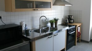 A modern kitchen with a stainless steel sink, a Bosch microwave, and a coffee maker. - Apartment in Moselkern in the Countryside (Moselkern)