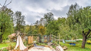 A rustic outdoor area with a wooden deck, a small shed, and a hammock. - Apartment in Marktrodach With Sauna & Garden (Marktrodach)