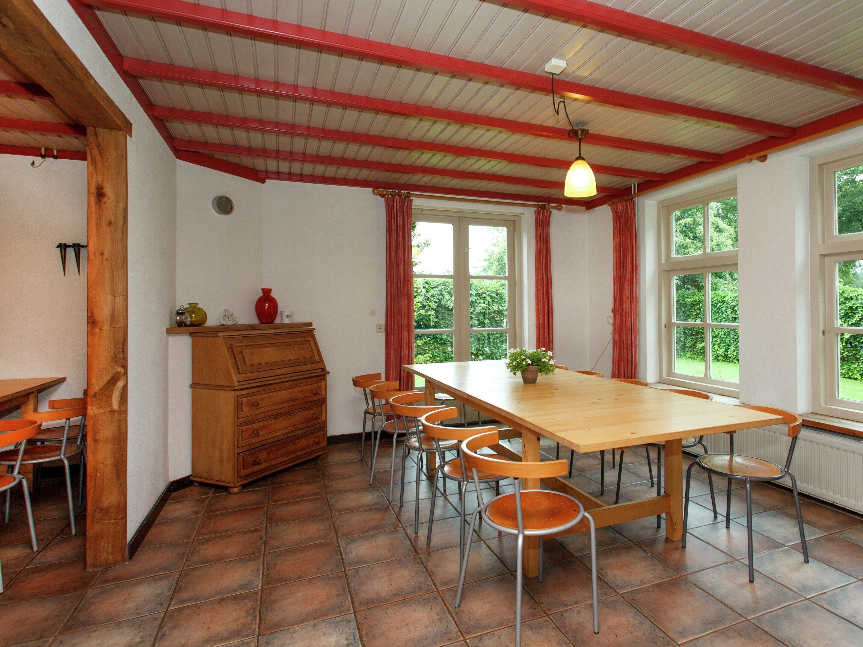Un coin repas avec une table et des chaises en bois, une commode en bois et une fenêtre avec des rideaux.