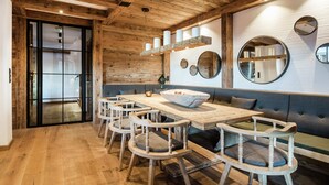Un interior de madera con una larga mesa de comedor, sillas y un banco.