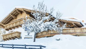 Un edificio de madera con un letrero que dice 'Lodge of Joy' en un paisaje nevado.
