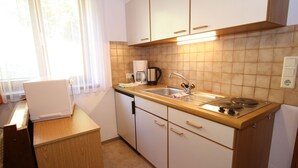 A compact kitchen with a sink, stove, and a coffee maker. - Apartment in Wagrain at the ski Lift (Wagrain)