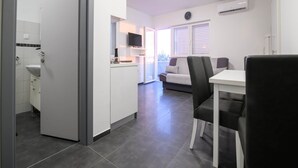 Una cocina moderna con armarios blancos, horno empotrado y ventana.