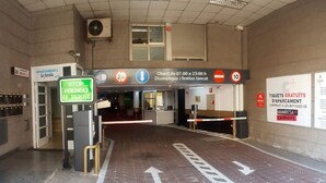 A train station entrance with ticket barriers, a sign indicating the ticket office is open from 07:00 to 23:00, and a sign for free parking in the apartment. - Duplex 3-3 La Farola (Manresa)