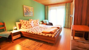 Una camera da letto con un letto in legno, un comodino, una sedia, una scrivania e un quadro appeso al muro.