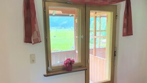 A room with a wooden door and a window with a view of a fenced yard. - Cosy Apartment in Neukirchen near Krimmler Waterfalls (Neukirchen am Grossvenediger)