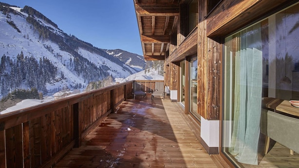 A wooden deck with a view of snow-covered mountains.