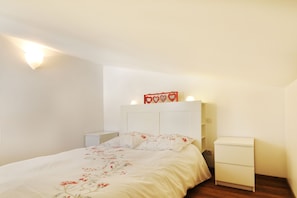 Un dormitorio con cama, mesitas de noche y un aparador.