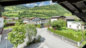 A residential area with houses, a street, and a view of green hills in the background. - Spacious Apartment near Ski Area in Niedernsill (Niedernsill)