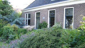 A brick building with a garden in front. - Waterfront Stelp Farmhouse With Sauna (Molkwerum)