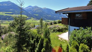 Ein Haus mit einem Balkon mit Blick auf eine gebirgige Landschaft.