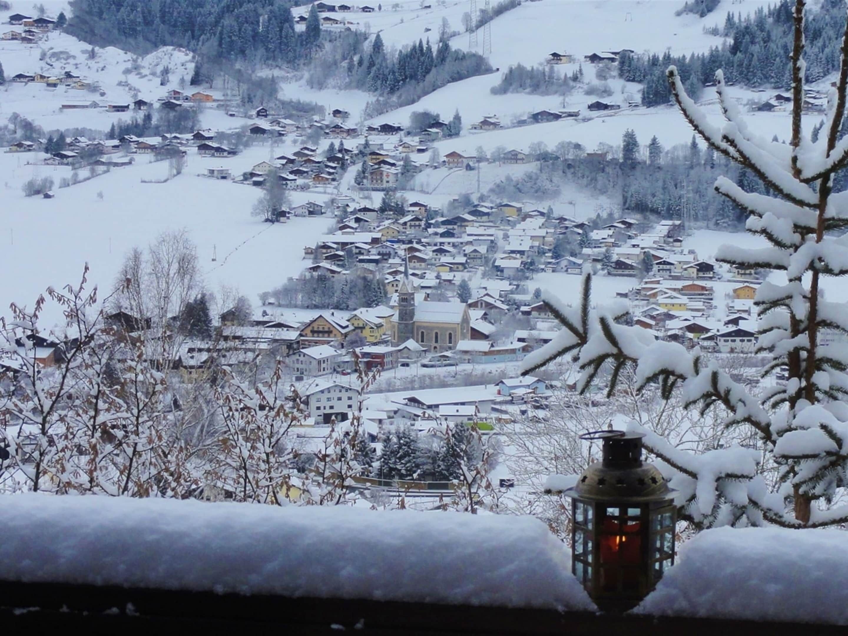 Un village enneigé, avec des maisons traditionnelles et une église imposante.