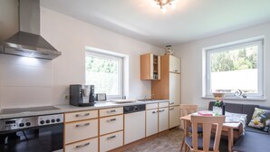 Una cocina moderna con estufa integrada, cafetera y armarios de madera.