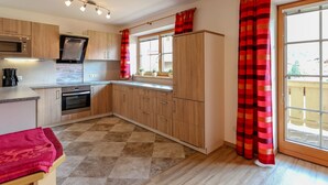 Une cuisine moderne avec des meubles en bois, un four encastré et un four à micro-ondes.