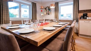 Un espace repas moderne avec une table en bois dressée pour six personnes, entourée de chaises rembourrées.