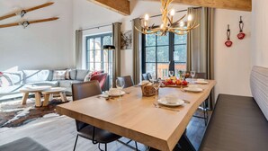 A dining area with a wooden table set for four, a sofa, and a bench. - Chalet in Krimml Near Zillertal Ski Arena (Krimml)