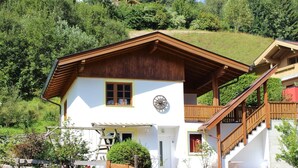 Eine zweistöckige Chalet mit Holzbalkon und einer Treppe zum Obergeschoss.
