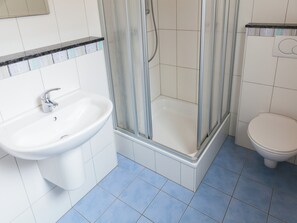A bathroom with a sink, toilet, and glass-enclosed shower. - Forest-edge Family Retreat (Kappel)
