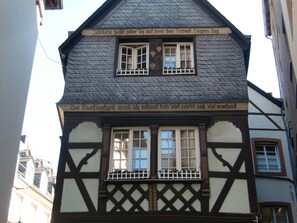 A traditional half-timbered building with two windows and a balcony.